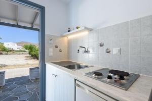 a kitchen with a sink and a counter top at Anna Studios Paros in Naousa +32 photos