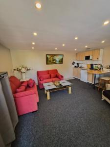 a living room with red couches and a kitchen at Luxe-Home in Châtenoy-le-Royal