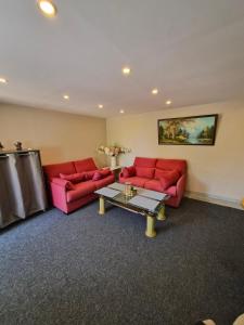 a living room with two red couches and a table at Luxe-Home in Châtenoy-le-Royal