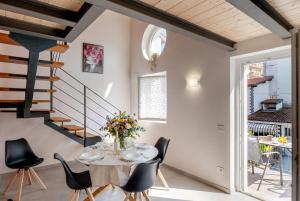 a dining room with a table and chairs and a staircase at Casa Quadrifoglio - Ticino in Intra