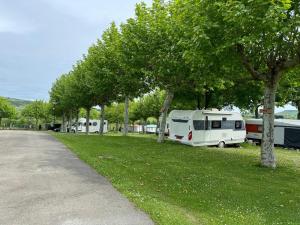 a group of rvs parked in a field with trees at Altamira Camping in Queveda