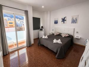 a bedroom with a bed and a large window at Tamonante rooms in Gran Tarajal +6 photos