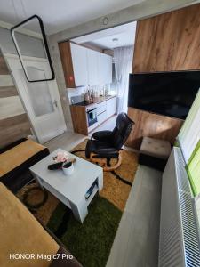 a small living room with a table and a chair at Teslić Apartman NiA in Teslić