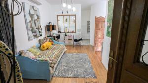 a living room with a blue couch with a stuffed animal on it at Chambre d'Hôtes La Grenade Bleue in Pons