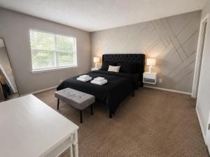 a bedroom with a bed and a table and a window at Maple n Main Hoover Modern 2BR Escape 2E in Hoover