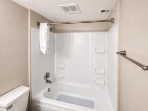 a white bathroom with a tub and a toilet at Maple n Main Hoover Modern 2BR Escape 2E in Hoover
