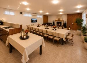 a dining room with tables and chairs and a kitchen at Villa Eloris in Pismenovo