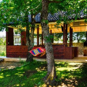 a hammock hanging between two trees in a yard at Villa Eloris in Pismenovo