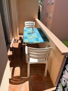 a small balcony with a table and chairs on it at 50 pas de l'Ô in Saint-Cyr-sur-Mer