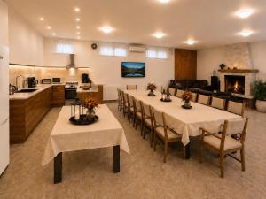 a dining room with tables and chairs and a kitchen at Villa Eloris in Pismenovo