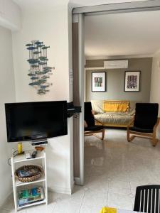 a living room with a tv and a couch at 50 pas de l'Ô in Saint-Cyr-sur-Mer