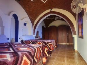 a bedroom with two beds and an archway at Healing House in Luxor