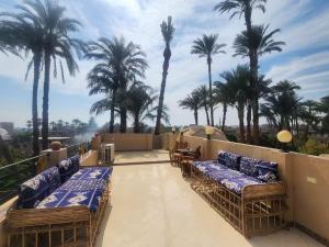 a balcony with wicker chairs and palm trees at Healing House in Luxor