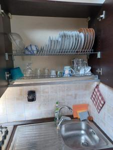 a kitchen sink with plates and dishes on a shelf at Scoglietti Loft in Ventimiglia