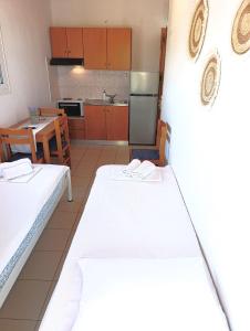 two beds in a room with a kitchen and a table at Villa Christina Sea Side A in Hanioti