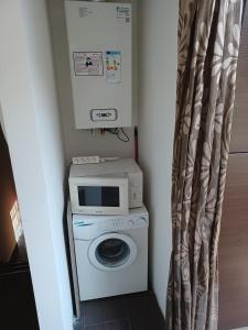 a laundry room with a washing machine and a microwave at Scoglietti Loft in Ventimiglia
