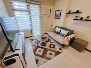 a living room with a couch and a table at Roomy 1BR Balcony-40sqm-4px-PET-Parking-MOA,PICC,WTC,CCP in Manila