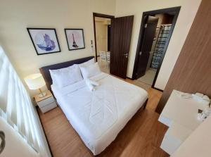 a bedroom with a large white bed with two tables at Roomy 1BR Balcony-40sqm-4px-PET-Parking-MOA,PICC,WTC,CCP in Manila +49 photos