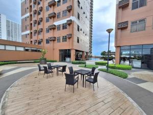 a patio with tables and chairs in front of a building at Roomy 1BR Balcony-40sqm-4px-PET-Parking-MOA,PICC,WTC,CCP in Manila