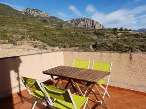 a table and chairs on a balcony with a view of a mountain at Casa rural Casa Camilo in Agüero