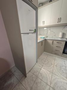 a kitchen with white cabinets and a refrigerator at Borsh Beach Apartment in Borsh +2 photos