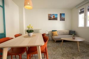 ein Wohnzimmer mit Tisch, Stühlen und Sofa in der Unterkunft Raízes 22 - Apartamento 1 in Puebla de Don Fadrique