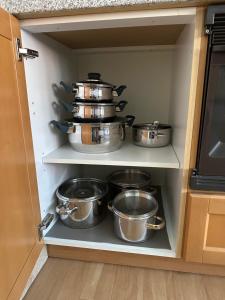 a cabinet filled with pots and pans in a kitchen at Haus Heinrich Heine in Ilsenburg