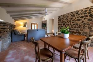 a dining room with a wooden table and chairs at Can Quel in Canet de Adri