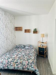 a bedroom with a bed and a table with a lamp at La morvandelle in Limanton