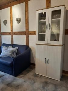 a living room with a blue couch and a cabinet at Gerkenhof in Olsberg