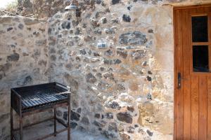 a stone wall with a bench next to a door at Can Quel in Canet de Adri