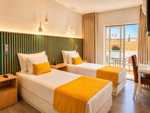 two beds in a hotel room with a balcony at Hotel Sol Algarve by Kavia in Faro +34 photos