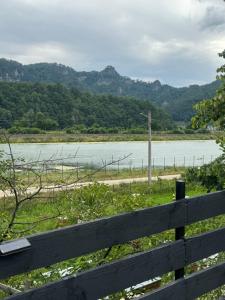 a view of a body of water with a fence at Vatra Bunătăților- By The Lake in Proeni