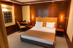 a hotel room with a bed and a desk at Garni Hotel Aleksandar in Novi Sad +34 photos
