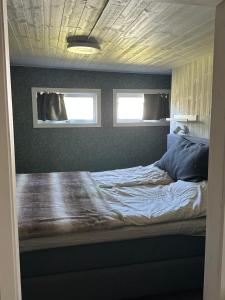 a bed in a room with two windows at Parkgatan in Vemdalen