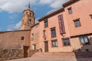 a large brick building with a clock tower at OTTIUM Albanuracín in Albarracín