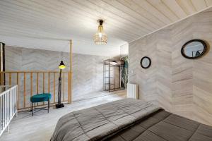 a bedroom with a bed and a clock on the wall at Gîte Du Tonnelier - 7min Puy du Fou in Sevremont