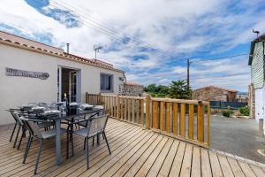 a wooden deck with a table and chairs on it at Gîte Du Tonnelier - 7min Puy du Fou in Sevremont