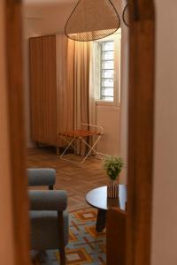 a living room with a chair and a table at Hôtel Rotonde Aix-en-Provence centre in Aix-en-Provence