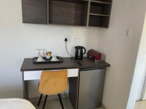 a desk with a coffee maker and a chair in a room at Cradle Mount Hotel Suites in Muldersdrift