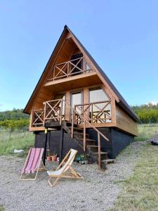 a building with two chairs and a house at Asureti Horizon Cottage in Asuretʼi