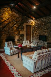 a living room with two couches and a stone wall at Casa De Anquiao - Turismo de Habitação in Ponte de Lima