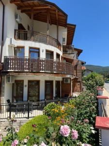 a large building with a balcony and some flowers at Yuliya Guest House in Sapareva Banya