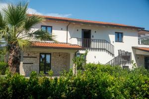 a house with a palm tree in front of it at Tre Fontane Country House in Sperlonga