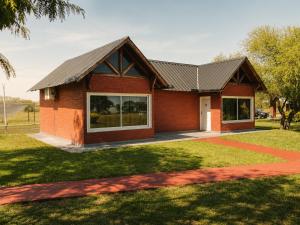 a red brick house with a metal roof at Rincon del Dorado Lodge in Goya +3 photos
