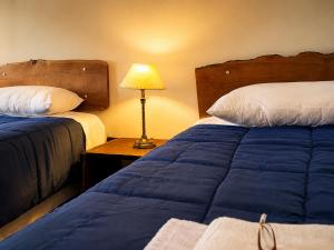 a hotel room with two beds and a lamp at Rincon del Dorado Lodge in Goya