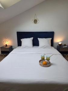a white bed with two bowls of fruit on it at Suite Attrape-Rêves - jardin - 2p in Sainte-Geneviève-des-Bois
