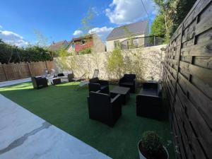 a patio with chairs and tables on a lawn at Suite Attrape-Rêves - jardin - 2p in Sainte-Geneviève-des-Bois