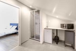 a white room with a bed and a tv on a counter at Suite Attrape-Rêves - jardin - 2p in Sainte-Geneviève-des-Bois