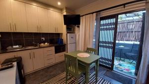 a kitchen with a small table and a kitchen with a window at A Little Guesthouse in Bloemfontein